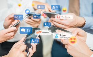 Image showing people holding cell phones with social media icons that represent their social media activity